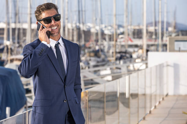 istock Cheerful male executive speaking on cellphone in port 1412825092