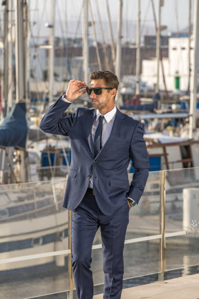 istock Businessman adjusting sunglasses in port 1412825099