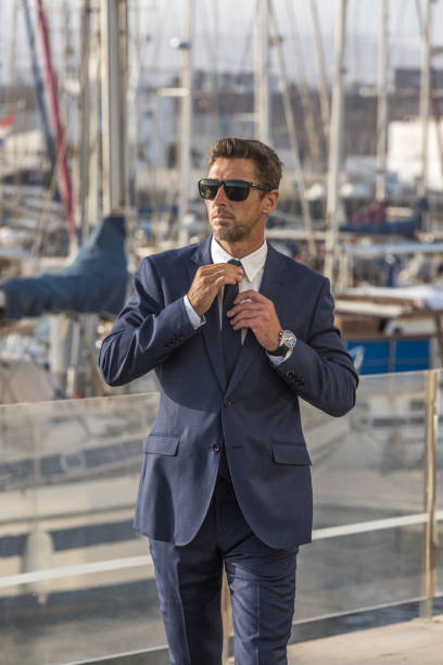 istock Businessman walking in port and adjusting tie 1412825100