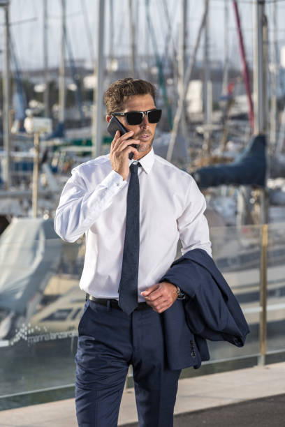 istock Serious businessman answering phone call in harbor 1412825173