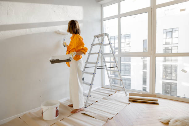 istock Woman paints wall, renovating her apartment 1412827403