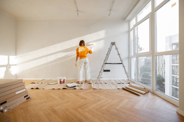 istock Woman paints wall, renovating her apartment 1412829072