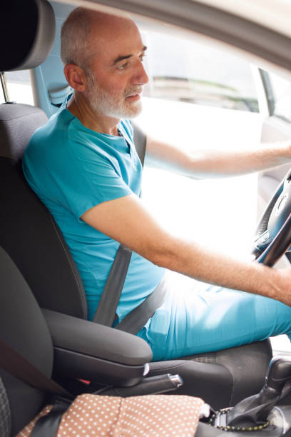 istock Happy male doctor, smiling and driving car after work 1412829103