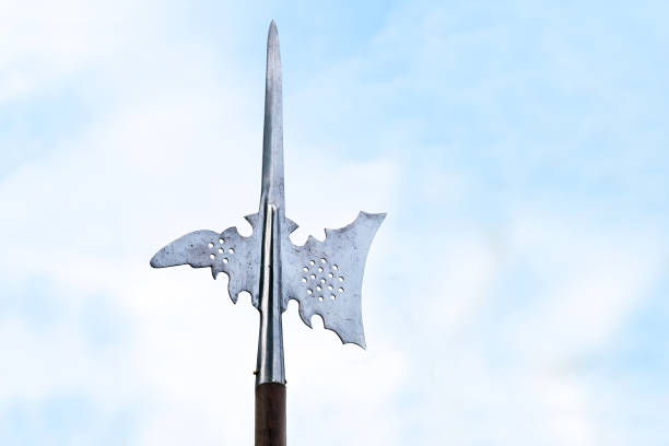 metal top of a halberd, also called halbard, halbert or swiss voulge, with axe blade and spike against a cloudy blue sky, pole weapon, copy space - halberd imagens e fotografias de stock