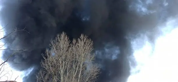 Smoke from fire on outskirts of the city after an air strike by Russian aircraft on the city. Horrors of war in Ukraine. Black smoke against sky. Fire during the war. Disaster