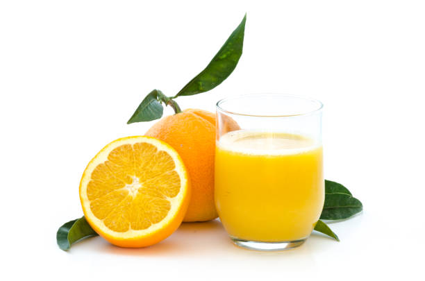 Fresh cut oranges and juice in a glass on white background stock photo
