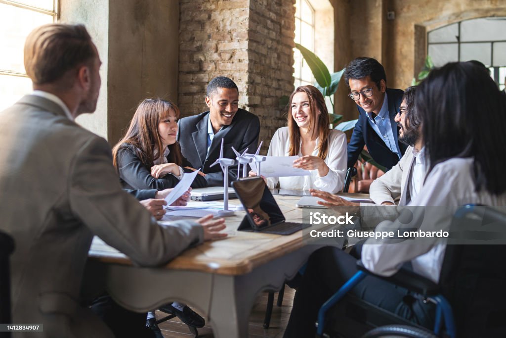 Group of multiethnic businesspeople discussing about financial strategy, renewable power, sustainable innovation project and environmental economical issues - business, sustainability interracial lifestyle concept Human Resources Stock Photo