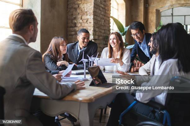 Group Of Multiethnic Businesspeople Discussing About Financial Strategy Renewable Power Sustainable Innovation Project And Environmental Economical Issues Business Sustainability Interracial Lifestyle Concept Stock Photo - Download Image Now