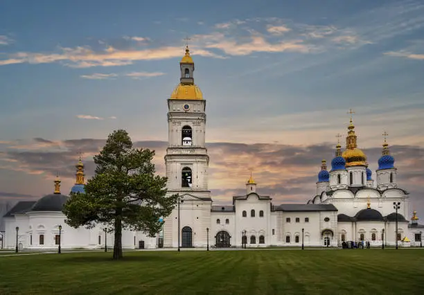 The complex of white-stone churches of the Tobolsk Kremlin, 17th century (Siberia, Russia) in the autumn evening. Included in the list of federal cultural values of the country. Golden domes, old pine