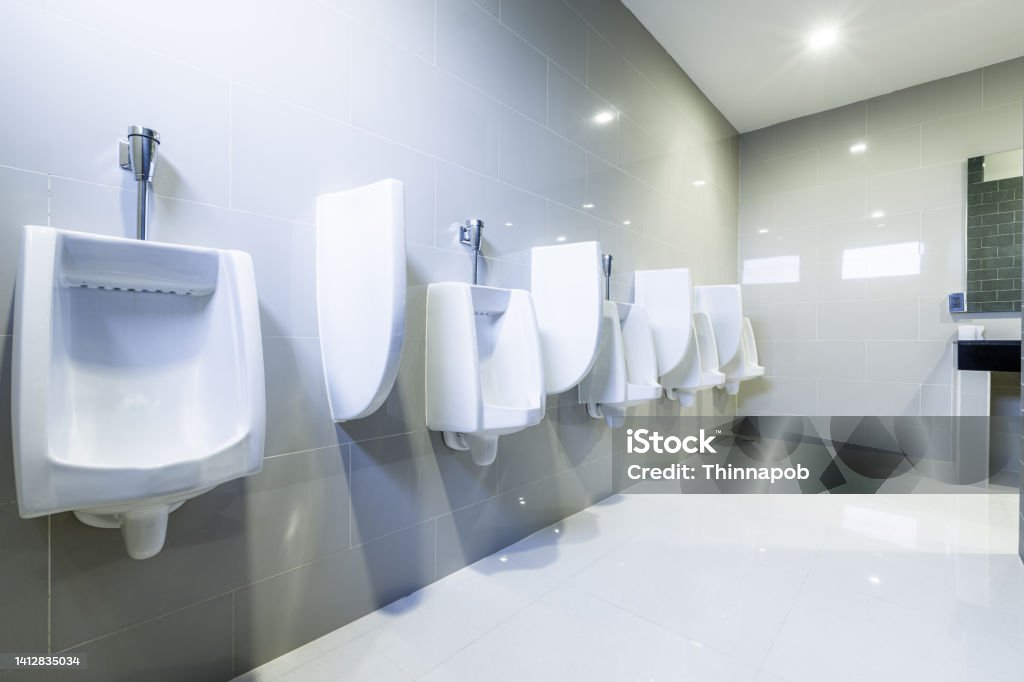Contemporary public Interior of bathroom with toilet urinals lined up Modern design, no privacy. Advertisement Stock Photo
