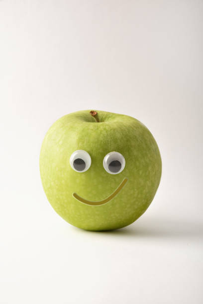 istock Healthy green apple with face on white isolated background 1412835336