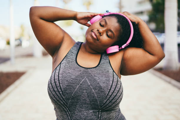 istock Happy curvy african woman doing stretching workout routine outdoor 1412836834