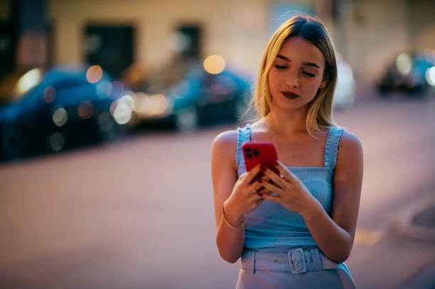 istock young woman on street using smartphone 1412838372