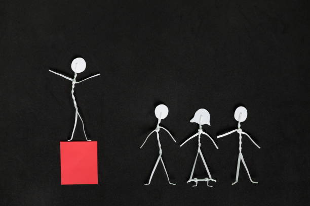 istock Good leadership concept. Human stick figure as leader on red platform. 1412844555