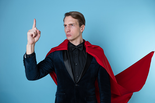 superhero stands in a heroic pose, a man in a business suit and a red cape. charismatic and successful business hero.