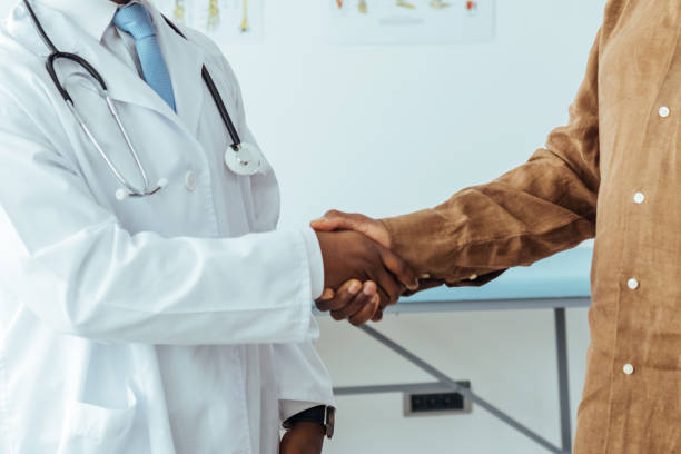 istock Senior man is shaking hands with healthcare worker 1412851333