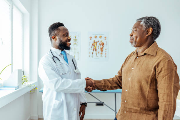 istock Smiling male doctor greeting senior man while standing. 1412851884