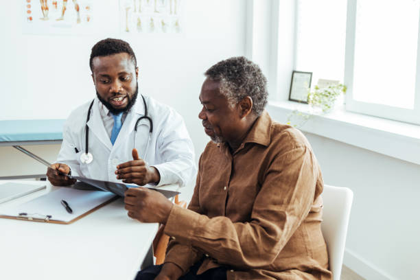 médecin masculin et patient âgé discutant des résultats de l’analyse au bureau. - patient doctor african descent hospital photos et images de collection