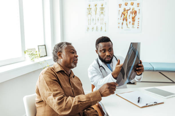 Man and radiologist looking at clear lung x-ray Man and radiologist looking at clear lung x-ray x ray image stock pictures, royalty-free photos & images