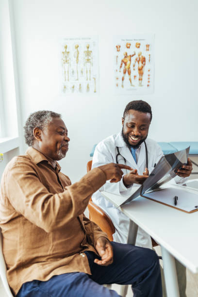 doctor showing x-ray image to patient - medical exam doctor patient adult imagens e fotografias de stock