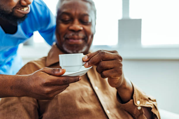 istock Caregiver serving coffee to senior man 1412852579