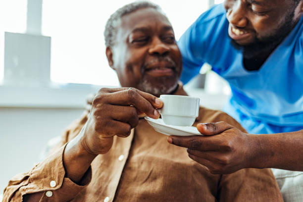 istock Male caregiver helping senior man 1412852677