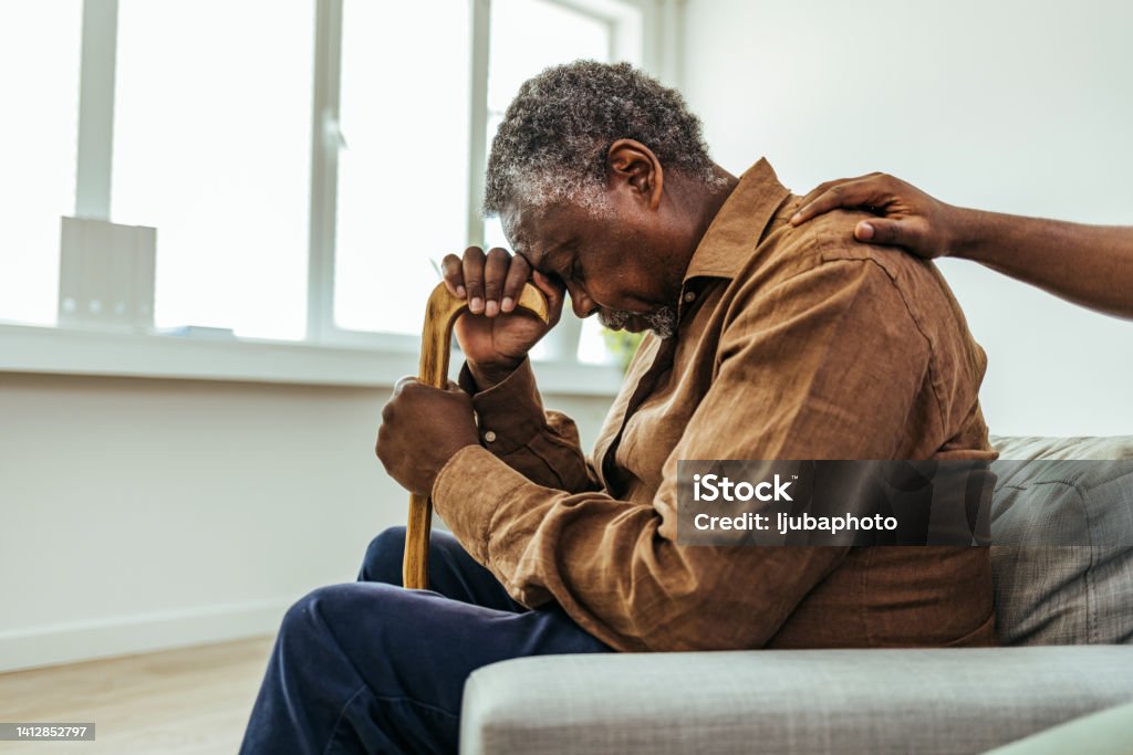 Senior man being cared for by a young nurse in a retirement home Senior Adult Stock Photo