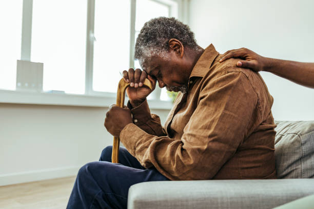 Senior man being cared for by a young nurse in a retirement home Senior man being cared for by a young nurse in a retirement home hospice stock pictures, royalty-free photos & images