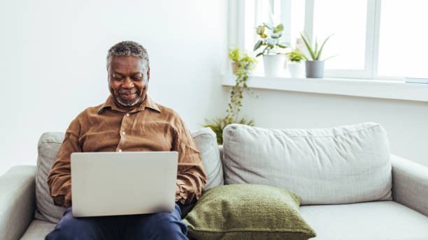 istock Senior man surfing on laptop in apartment 1412852825