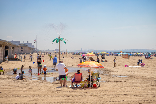 Coney Island, Brooklyn, NY, USA - June 25, 2022: People enjoying life on a hot and sunny day at the famous Coney Island beach