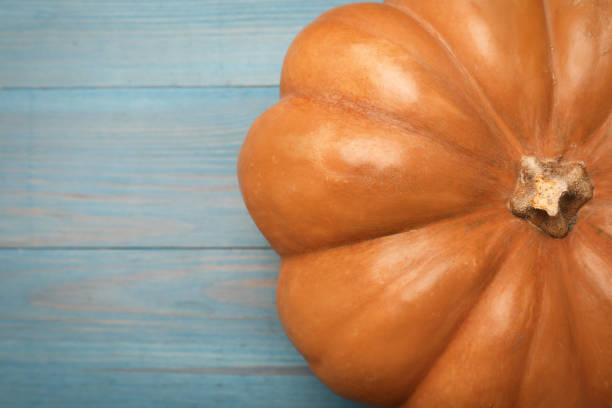 istock Fresh ripe pumpkin on turquoise wooden table, top view. Space for text 1412854465