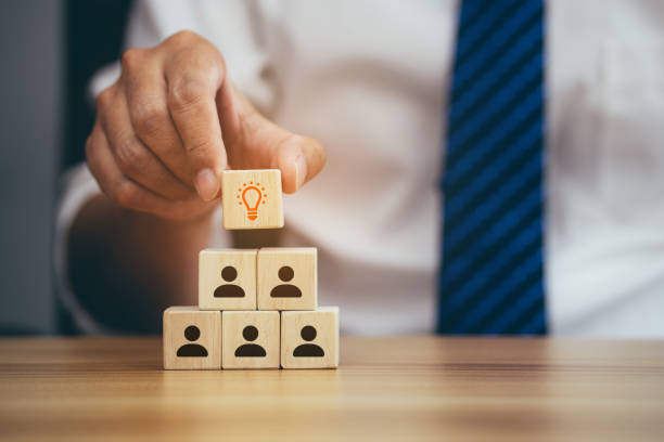 istock Businessman hands holding idea cube with many human symbol. 1412855433