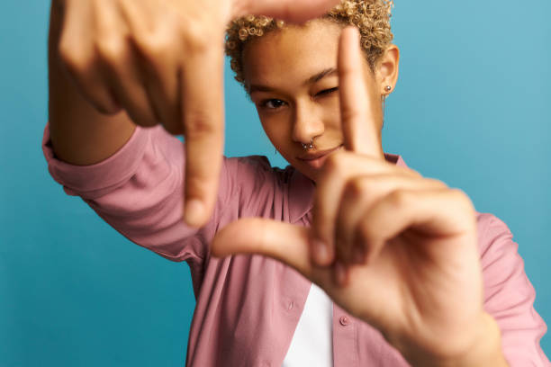 junge afroamerikanische frau mit sommerhut lächelt und macht rahmen mit händen und fingern mit glücklichem gesicht. kreativität und fotografisches konzept. - bildschaerfe stock-fotos und bilder