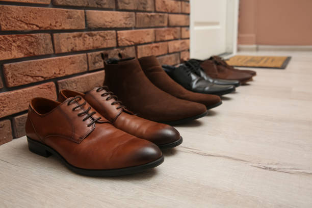 Stock flat lay, overhead photo of walking shoes & boots on a rustic brick paved surface