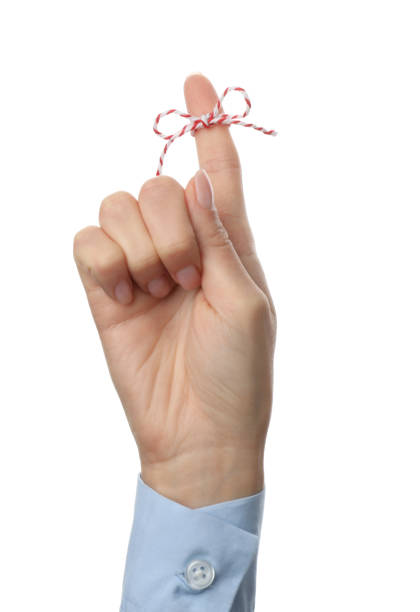 istock Woman showing index finger with tied bow as reminder on white background, closeup 1412858708