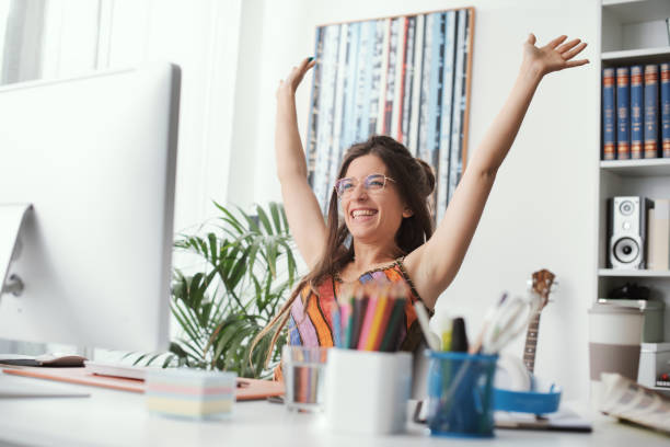 istock Cheerful woman sitting at desk 1412859609