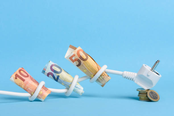 euro bills tied in knots in power electrical power cable on blue background - electric plug electricity power cable imagens e fotografias de stock