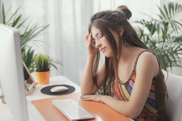istock Tired young woman with headache 1412860400