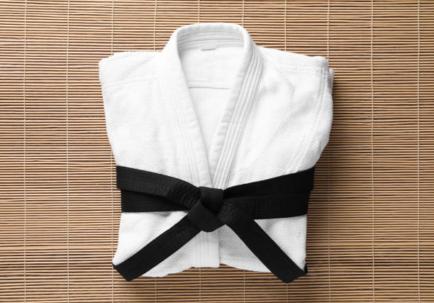 martial arts uniform with black belt on bamboo mat, top view - obi sash fotos imagens e fotografias de stock