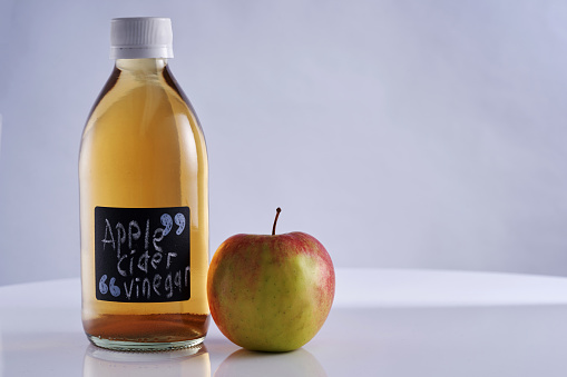 Close up  bottle of apple cider vinegar and fresh apple