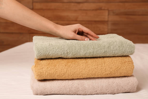 istock Woman touching soft towels on bed, closeup view 1412860716