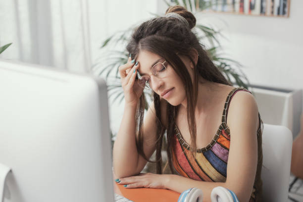 istock Tired young woman with headache 1412862928