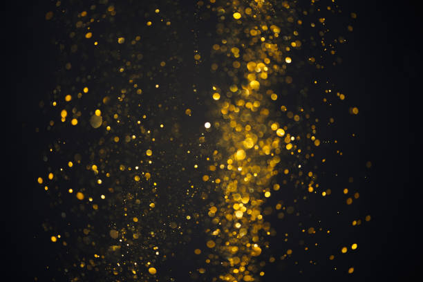 istock Glowing golden glitter shiny particles lights abstract bokeh 1412863069