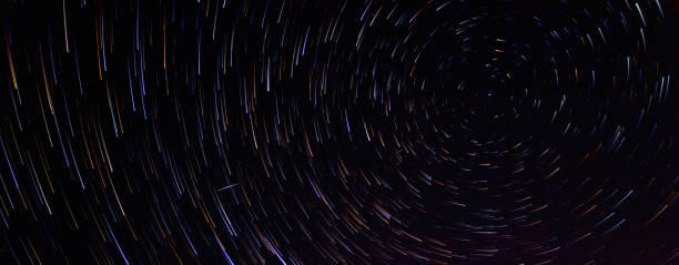 Star trails in the night sky with long exposure. Lines of colored stars. Movement of stars over the Earth stock photo