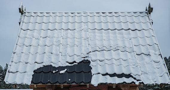 House with Asphalt Shingle Roof and Snow. Image shows, architectural asphalt shingle roof, vinyl siding, seamless aluminum gutters.