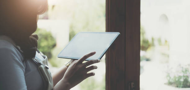 istock woman hands holding digital tablet with empty blank screen for your text message 1412865423