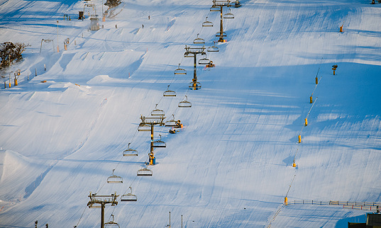 Snow field ski chair lifts on mountain