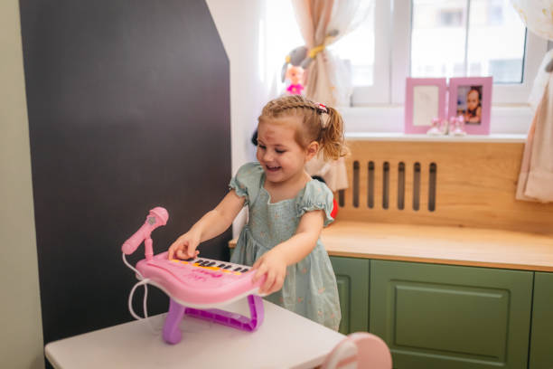 A cute child playing with a plastic piano