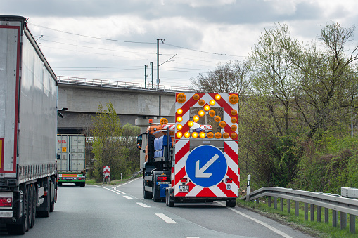 Kelsterbach, Germany - April 06, 2022: Road construction site at German highway A3 nearby Raunheim. A security vehicle indicates that the lane is closed.