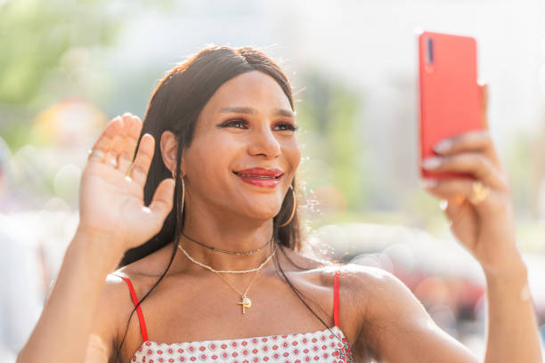 istock Trans woman gesturing hello at the mobile 1412869002